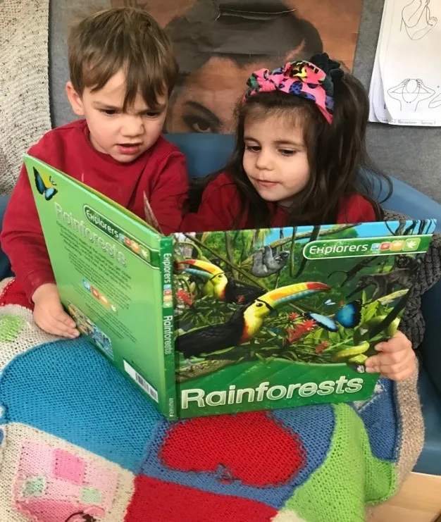 Children reading book about rainforests