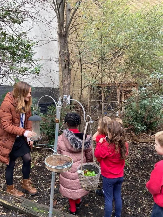 Early years children outside with an adult