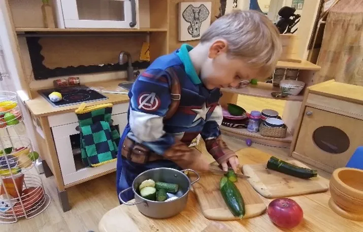 Child cutting cucumber