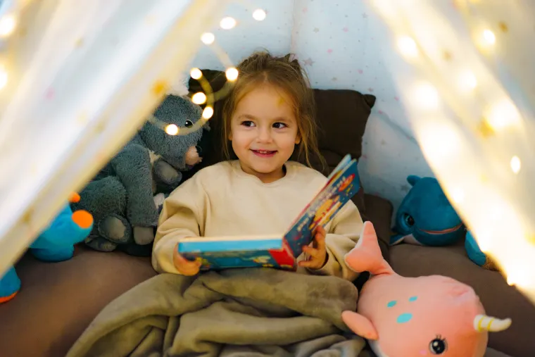 Little girl reading a book smiling