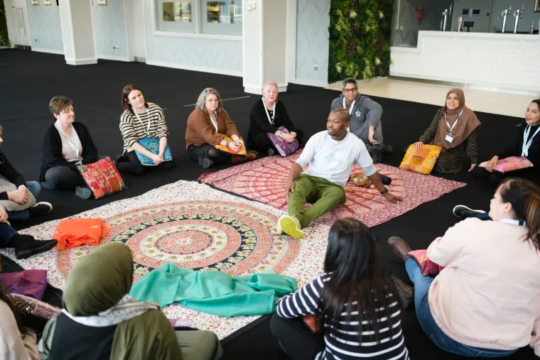 Photo of conference attendees participating in a well-being session at the Children at the HEART Spring Conference 2024