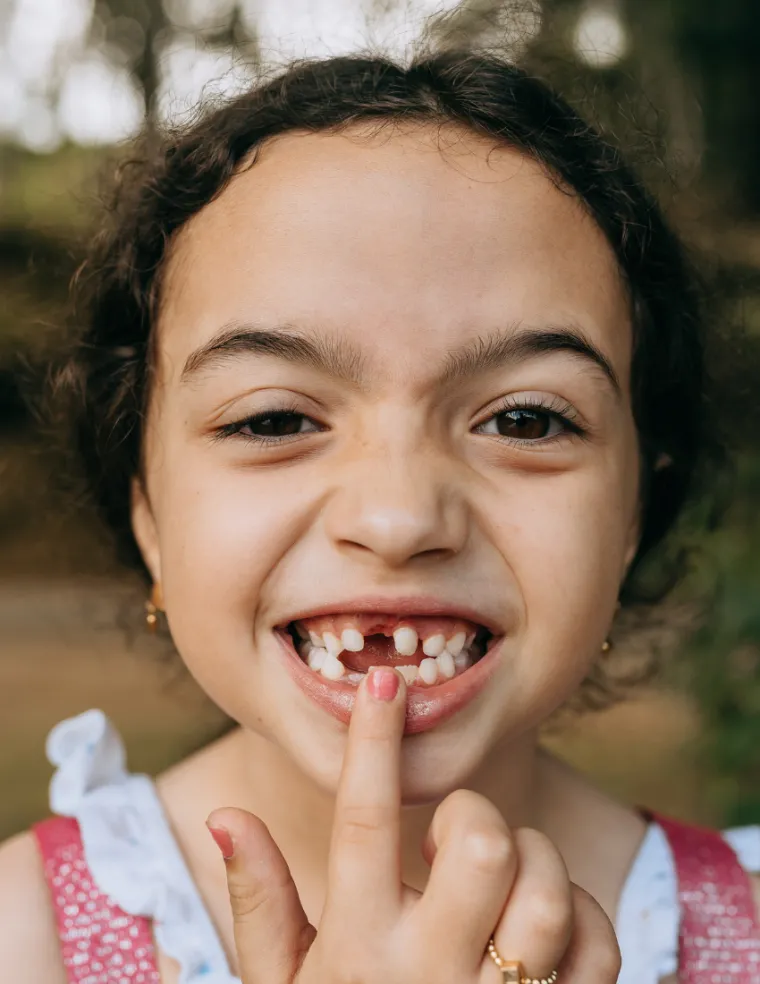 Close up photo of a young child showing their missing tooth