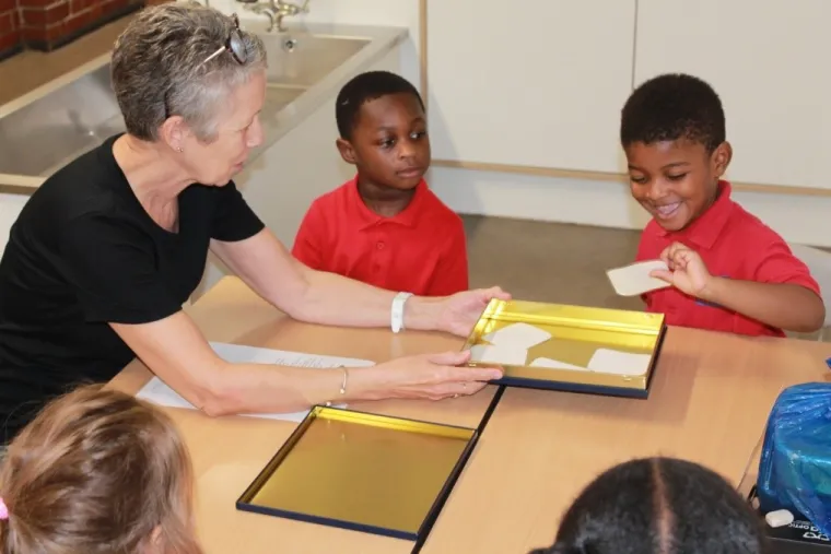 Adult with four early years children around a table
