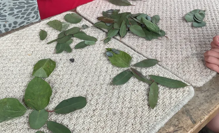 Leaves on a mat and childrens hands sorting them