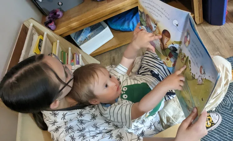 Woman reading book with child