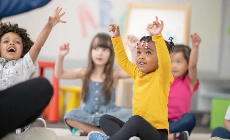 Early years children with hands in the air
