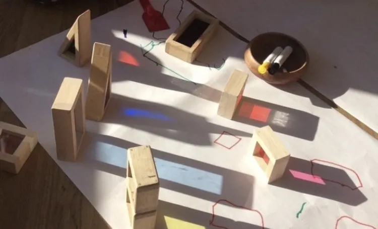 Image shows light shining through coloured cubes creating coloured patterns on paper. 
