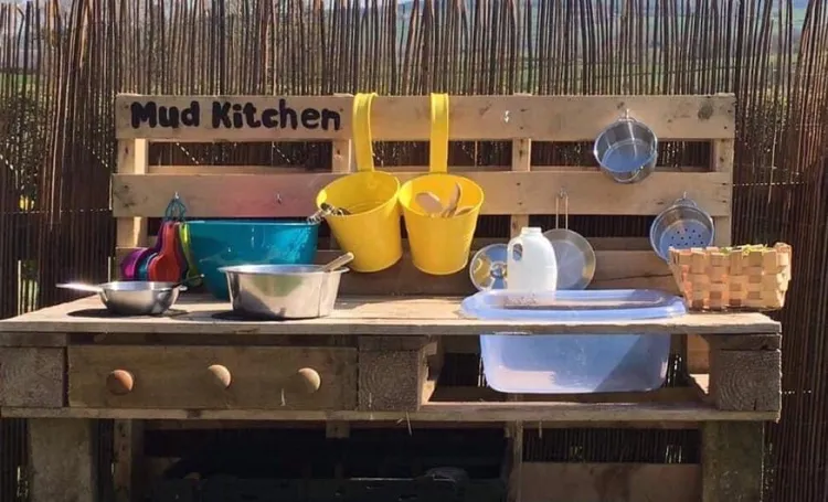 A mud kitchen in a garden with blue sky in the background