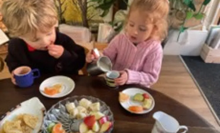 Two children in nursery enjoying a healthy snack together