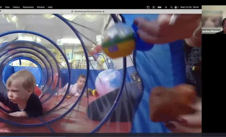 A young child crawling through a play tunnel in a nursery setting