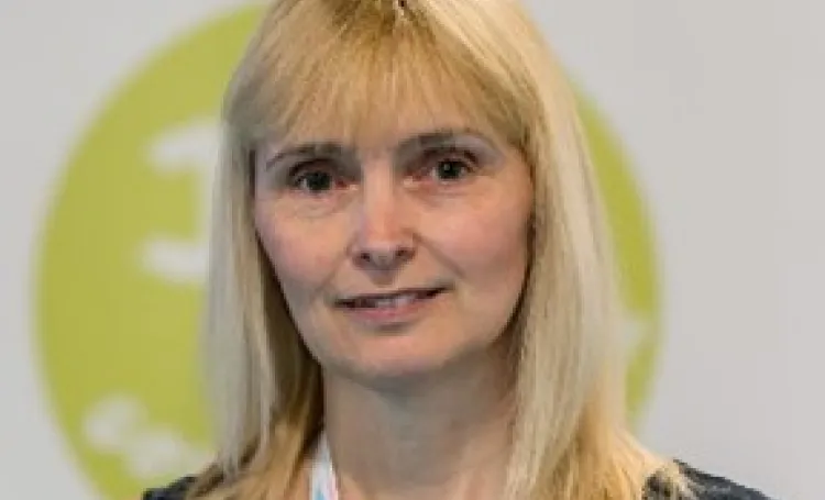 a portrait of author Sue Asquith, shoulder length blonde hair and black top, smiling 