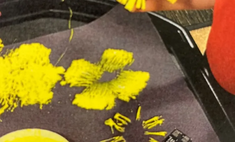 Child block printing with yellow paint