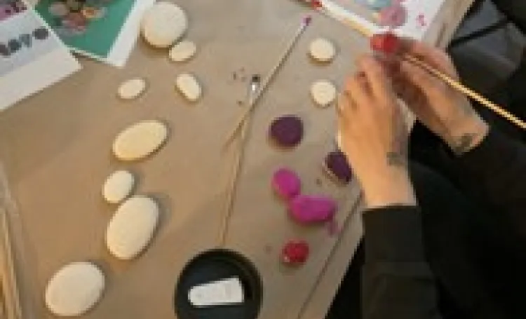 A table covered with loose parts linked to maths, with hands in painting stones.