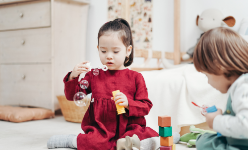 Two toddlers playing while sat down